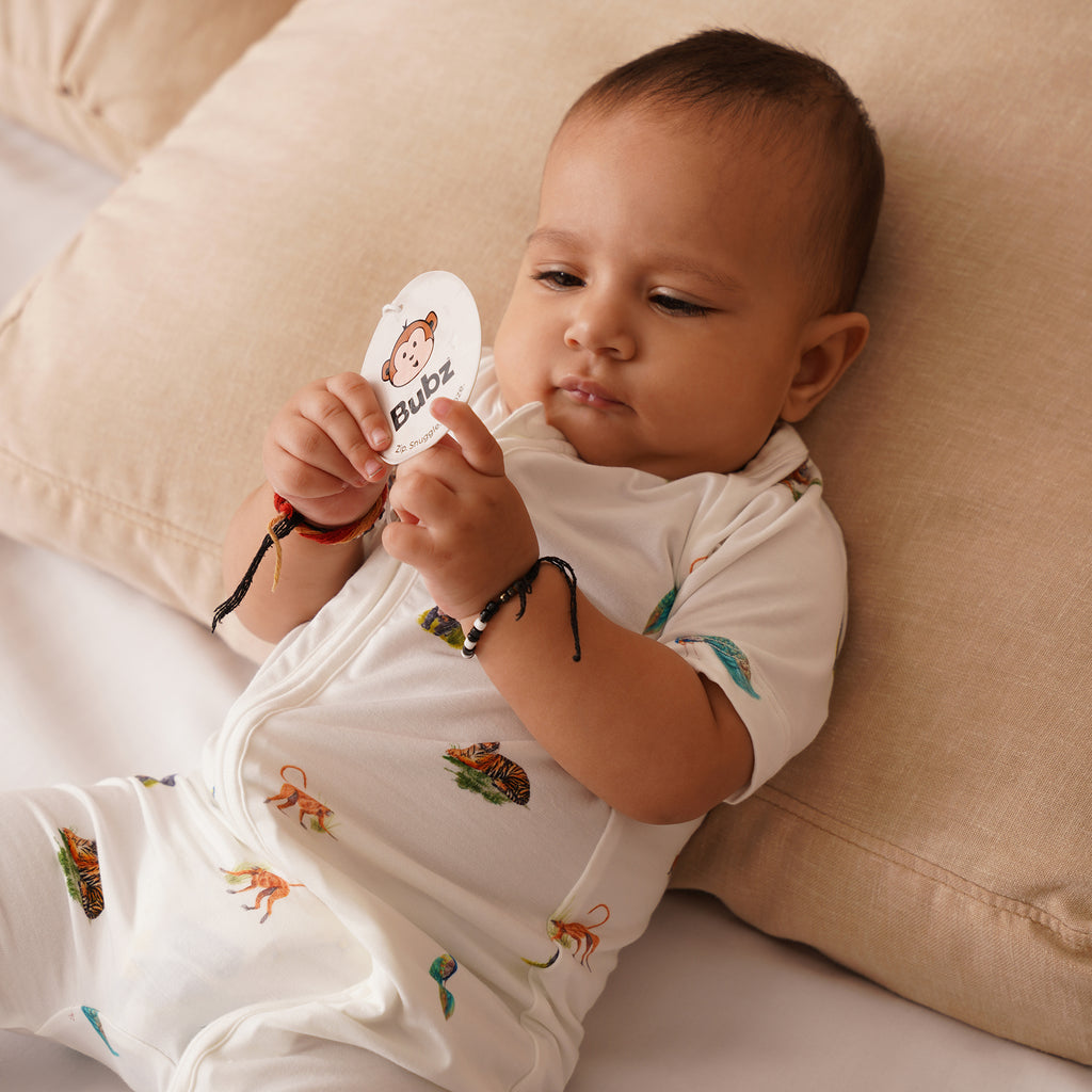 Baby laying down on pillow in animal print shortie outfit