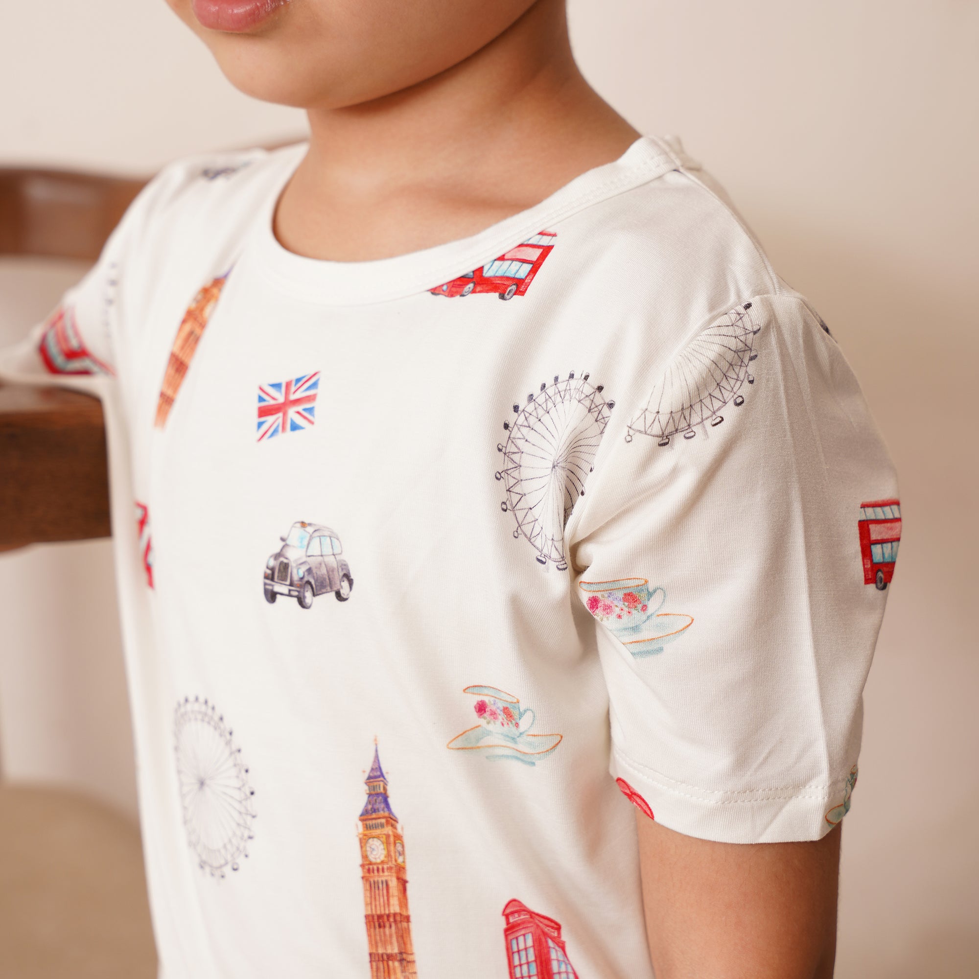 Child wearing a white t-shirt with london-themed designs.